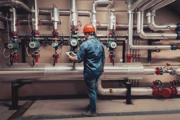 industrial boiler maintenance man working on some pipes